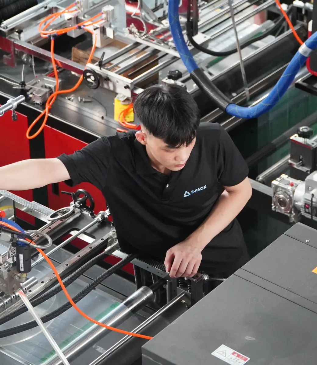 S-Pack technician operating a bag-making machine